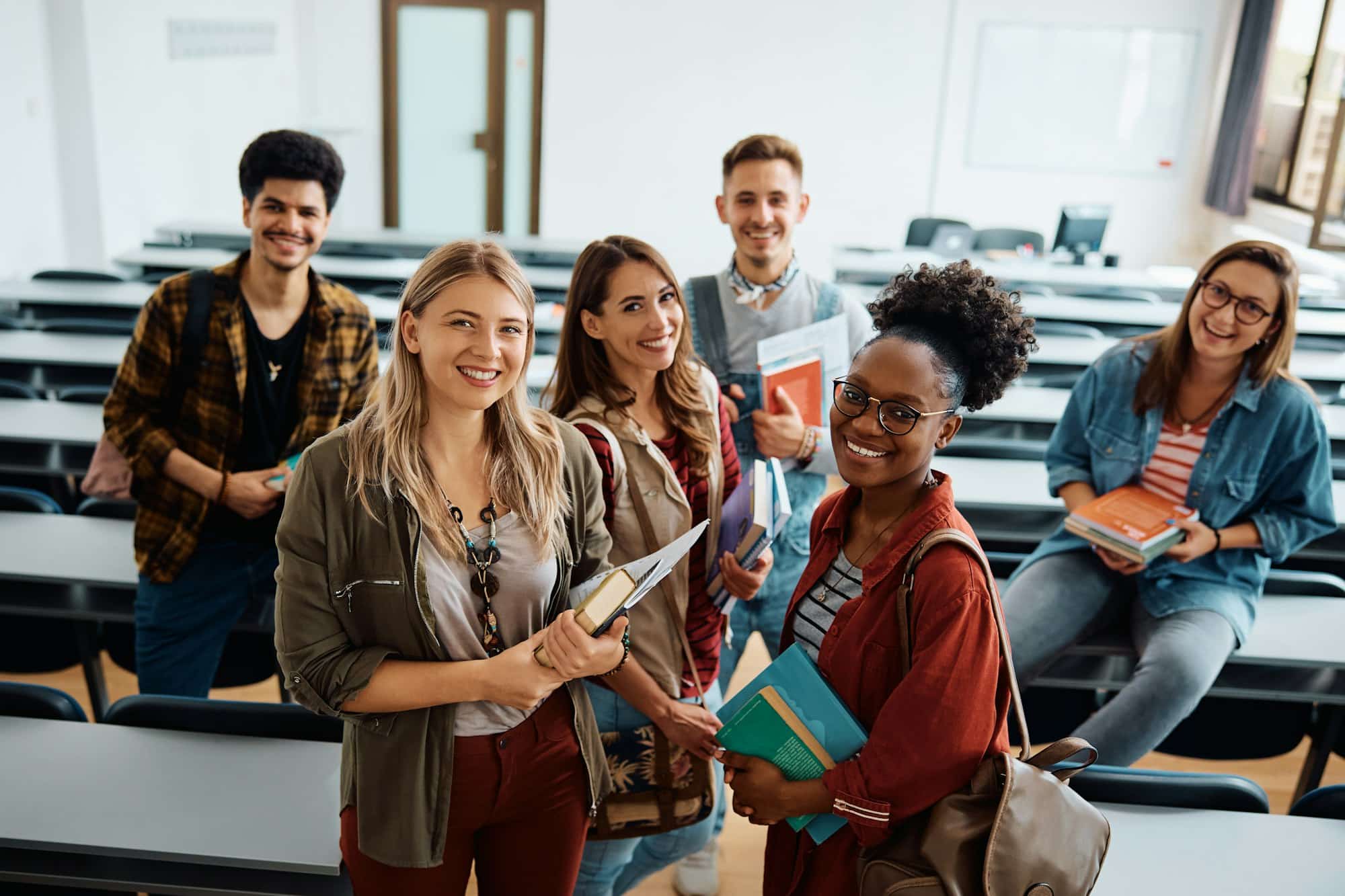 Multiracial Group Of Happy Students In Lecture Hall Looking At Camera